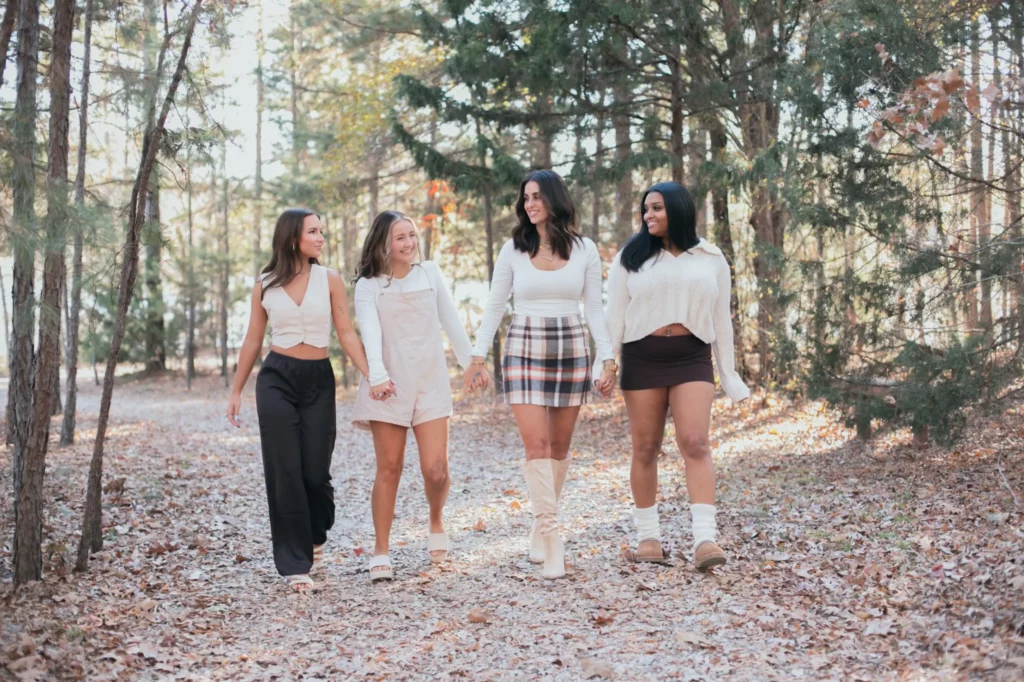 Four friends walking together on a forest path.